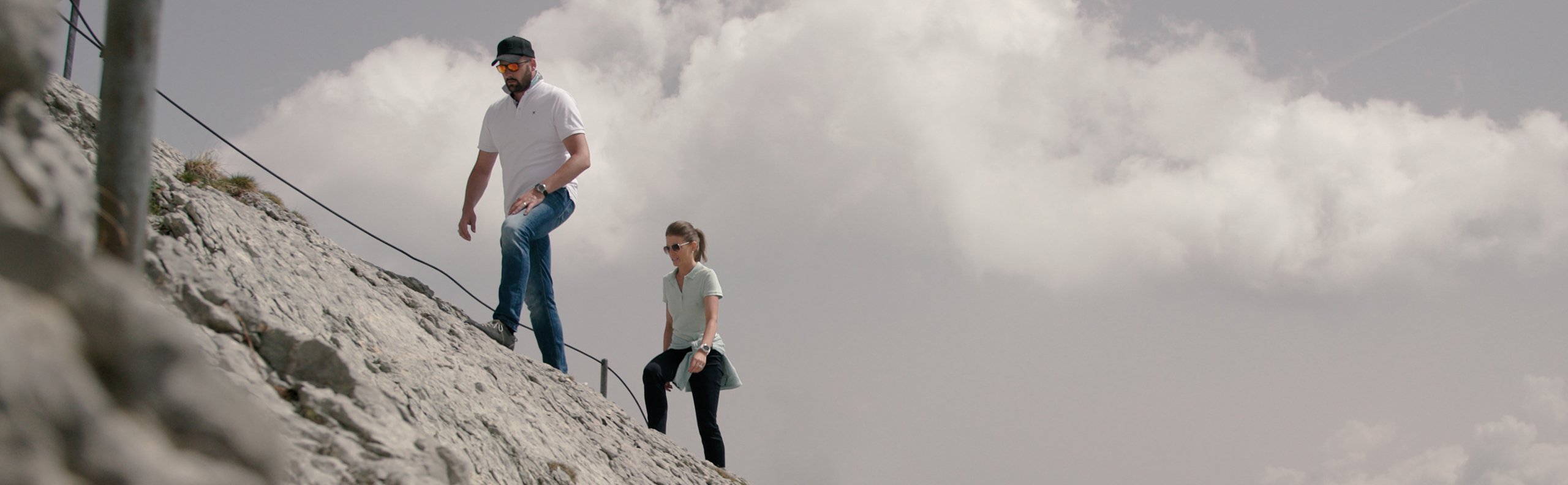 Ein Absolvent und eine Absolventin des Executive MBA beim Aufstieg auf einen Berg. 